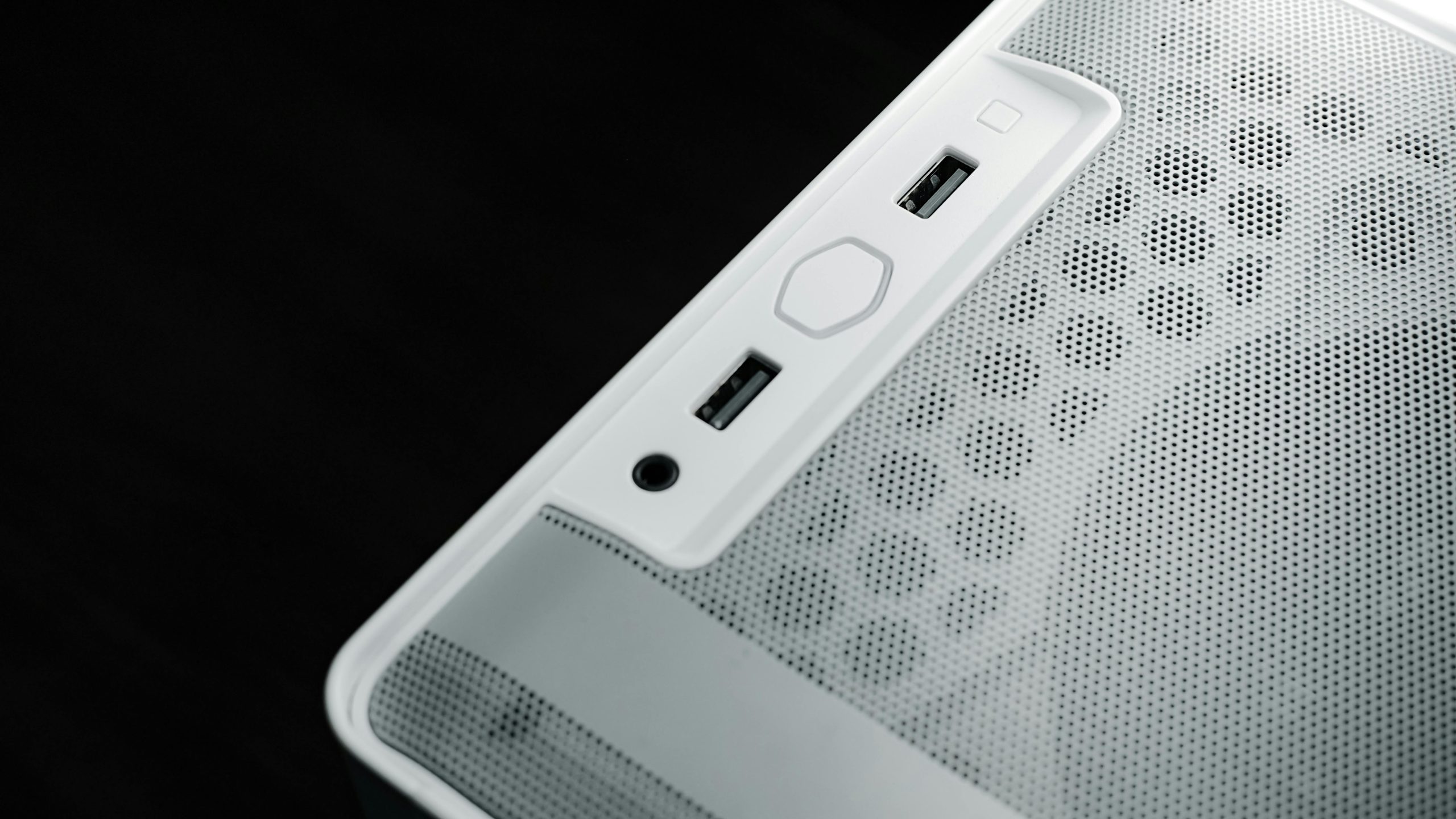 Detailed view of USB and audio ports on a white computer case, showcasing modern technology design.