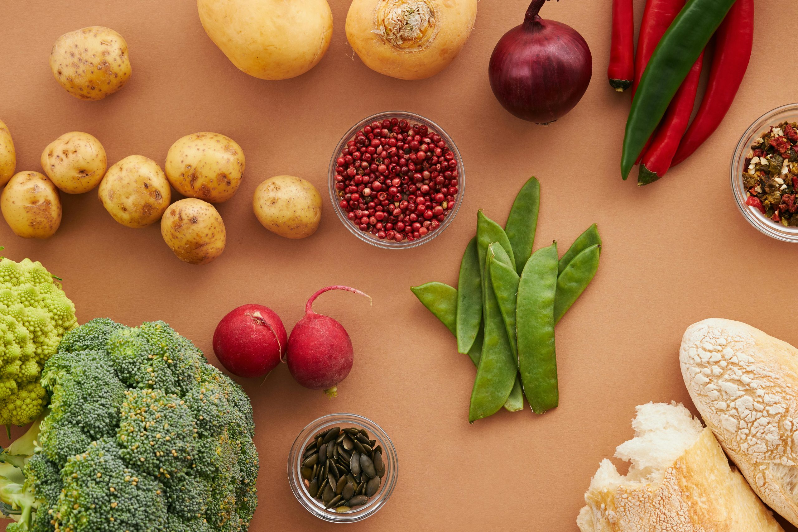 Top view of fresh ingredients including vegetables and bread, ideal for healthy cooking concepts.